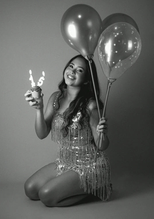 black and white pograph of a woman holding balloons