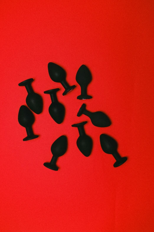 silhouetted black wine glasses on a red background