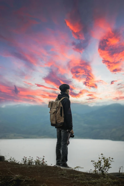 a person standing on a hill near water