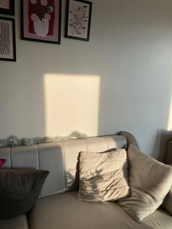 a couch and a white sofa with pillows against a wall