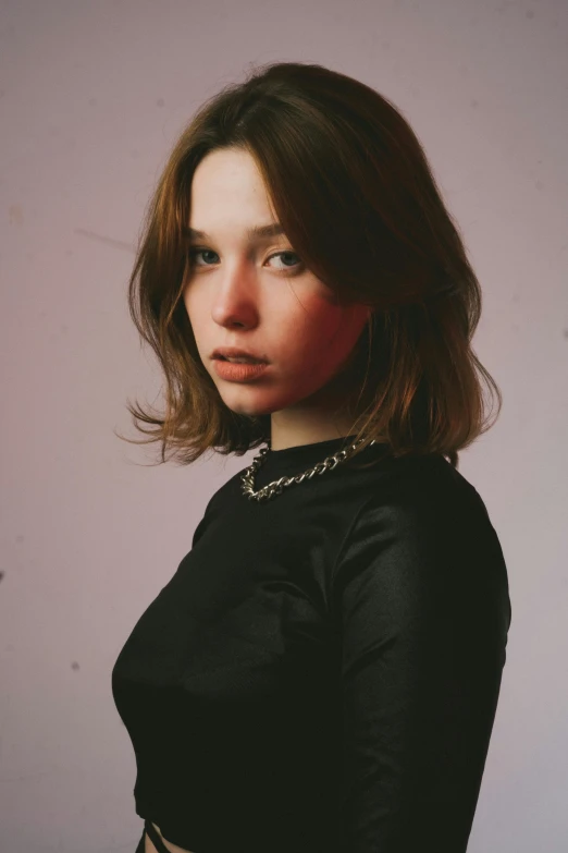 a woman in black shirt standing next to a wall