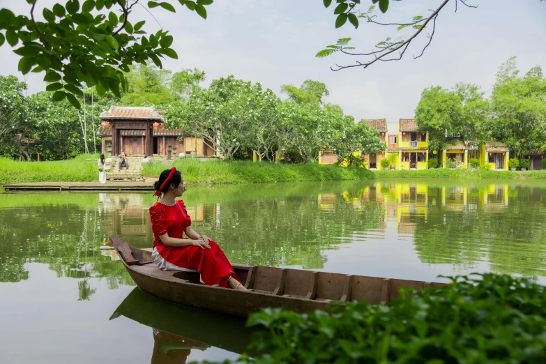 a woman in a red dress on a canoe