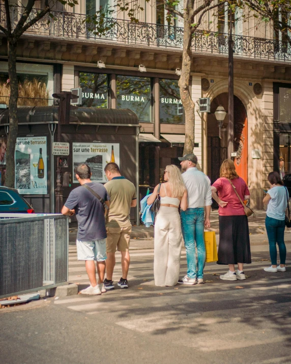 people standing on the curb waiting to cross the street