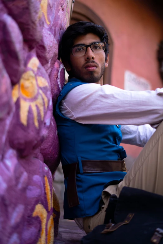 a man that is leaning up against a wall