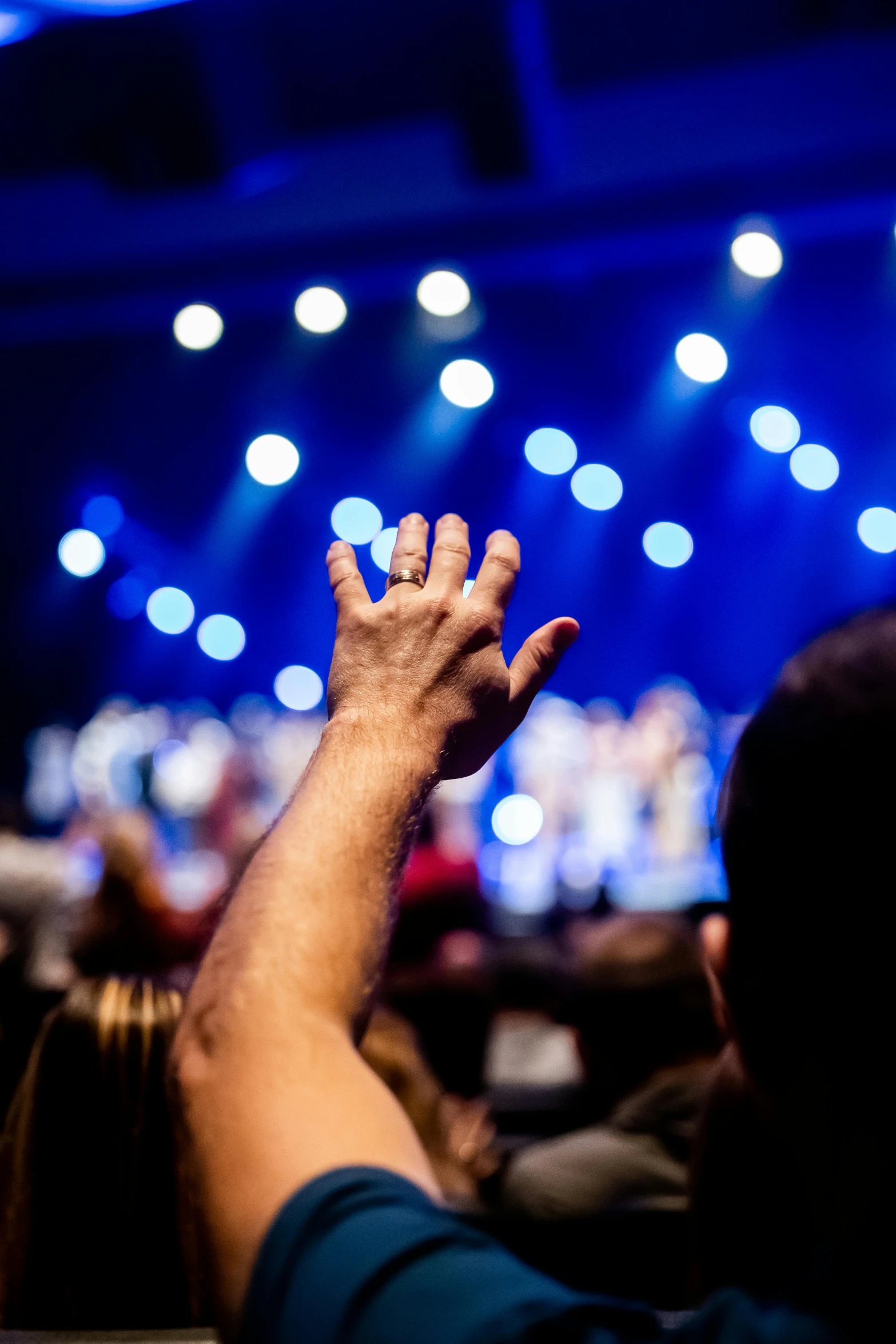 an audience is reaching their hand to hear soing