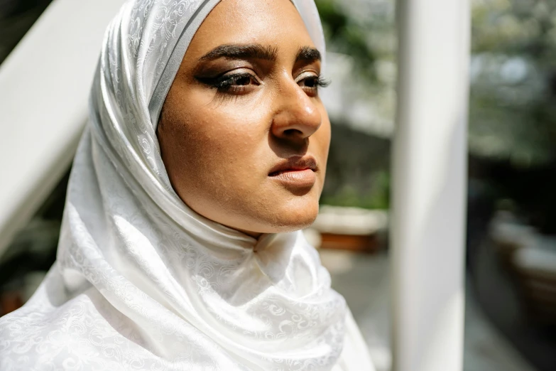 woman wearing white headscarf on street in urban setting