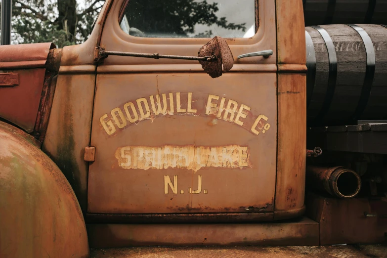 old orange truck with an odd logo that reads, goodtime fire company n j