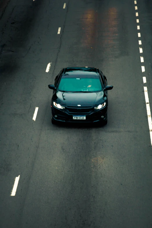 an asphalt highway with a black bmw sedan on it