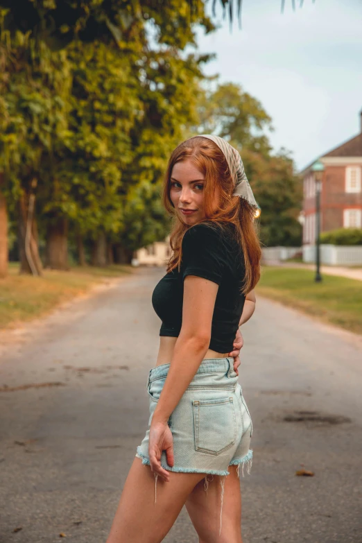 a woman in short shorts standing on a street corner