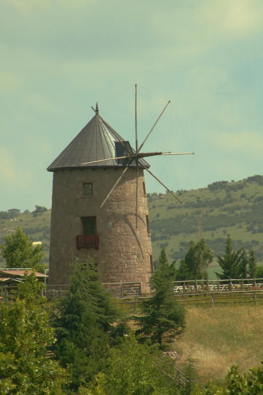 a windmill near trees on a sunny day