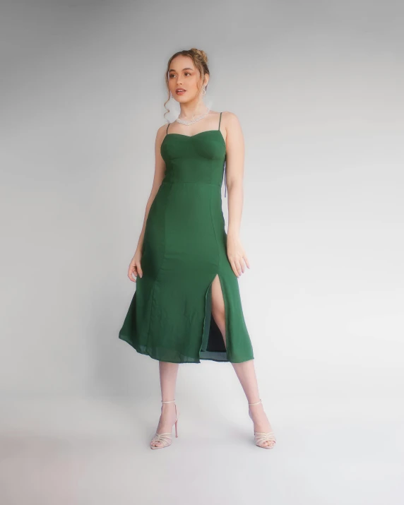 the woman wearing a green dress is standing up