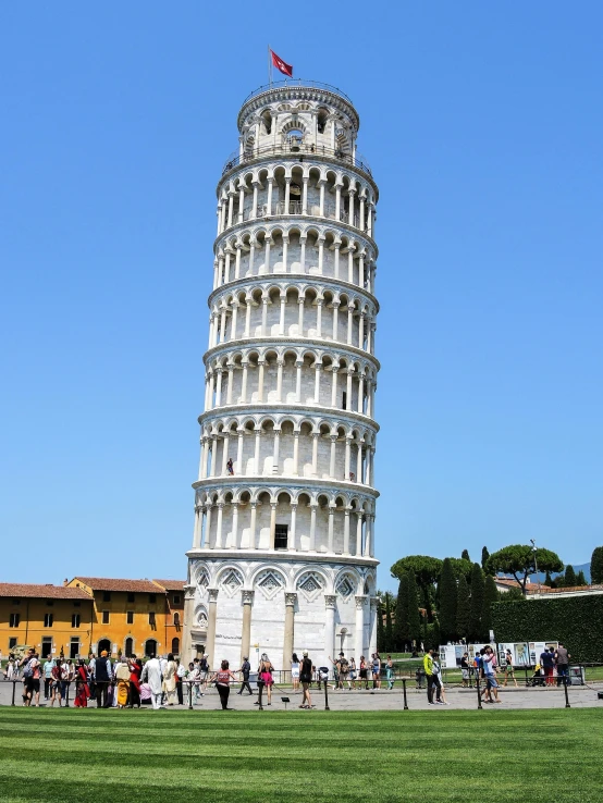 the leaning tower is very tall and has people looking at it