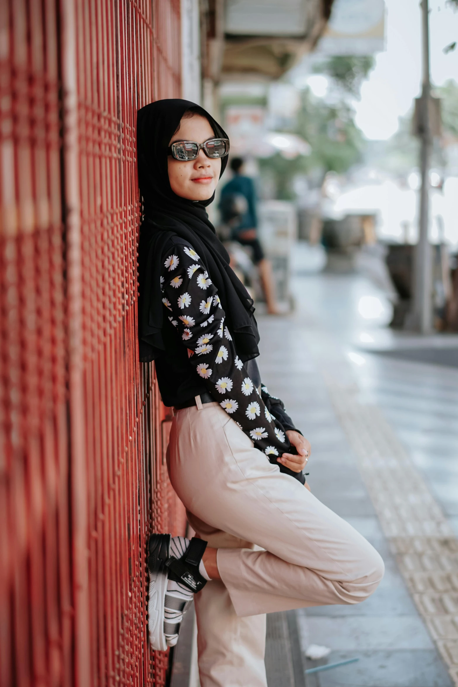 a  in glasses leans against a wall