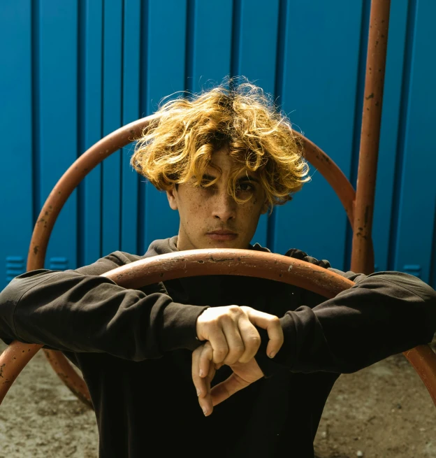 a man is sitting on a wooden chair with the steering wheel