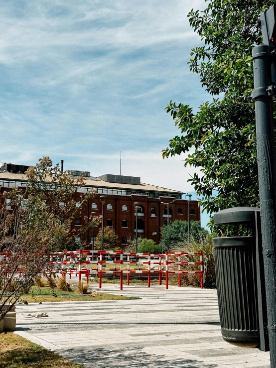 several trashcans in the yard next to a large building