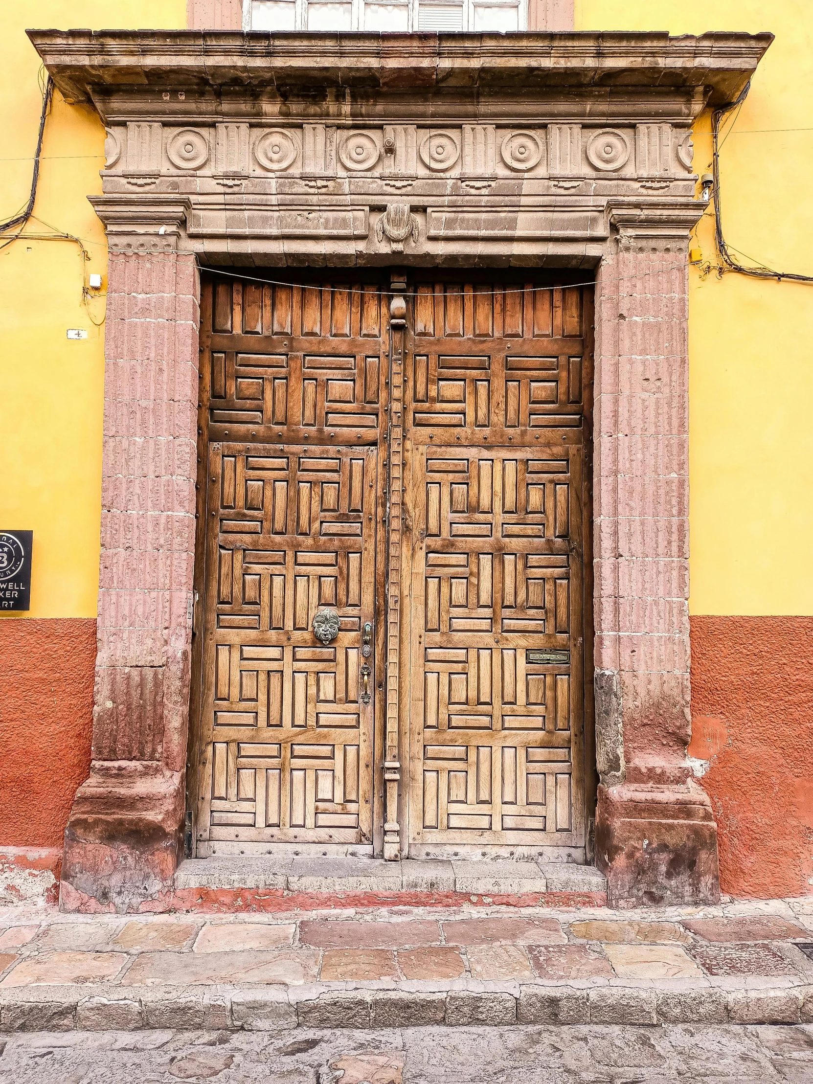 a building with wooden doors and graffiti all over it