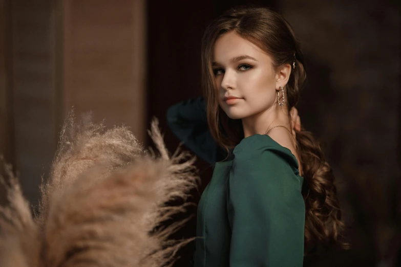 a young woman in green clothes with feathers in front of her