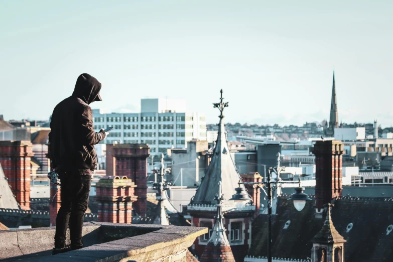 a person wearing a black jacket on top of a roof