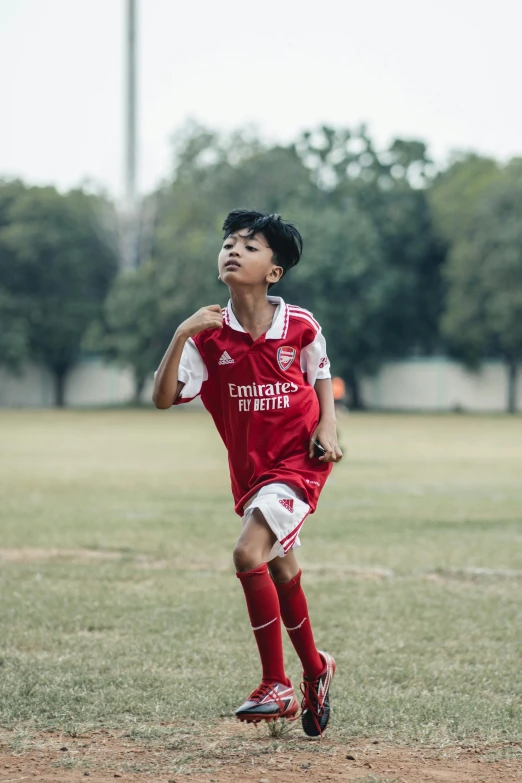  running on a soccer field while wearing red and white