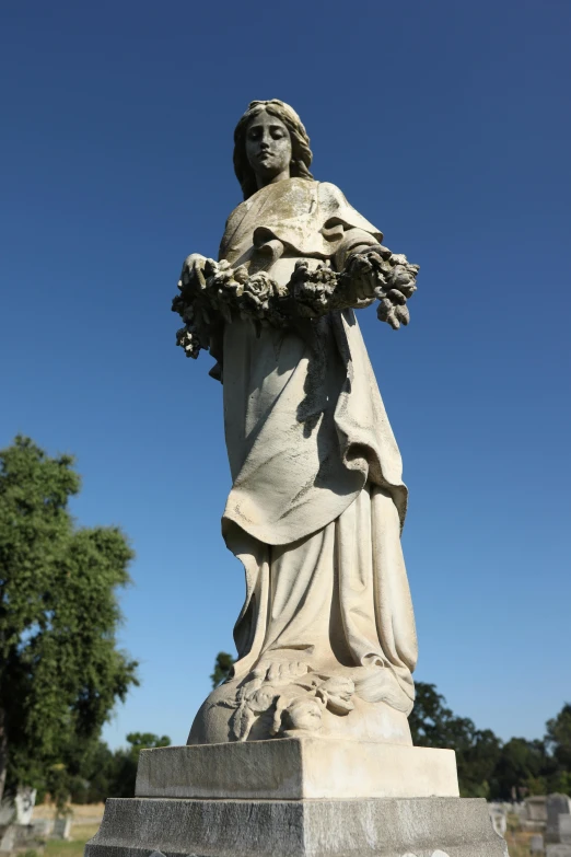 statue of a lady holding a bouquet in her hand