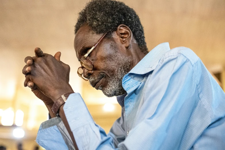 man in blue shirt and glasses looking down