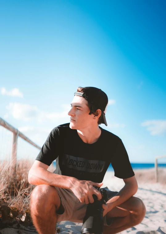 a man in a black t - shirt and some brown dirt and sand