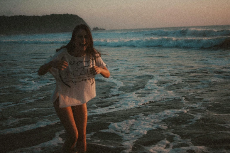 a woman walking on the beach holding a kite