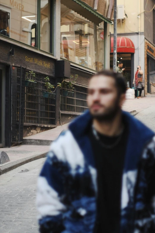 the man is walking down the street in front of the store