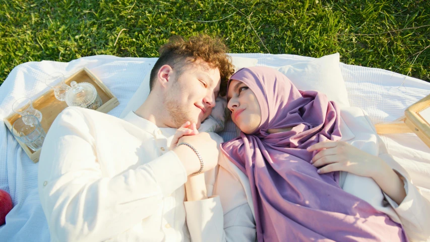 a couple is lying on the grass together