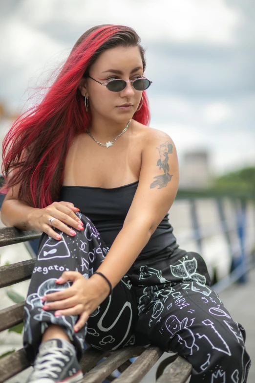 an attractive woman with red hair is sitting on a bench