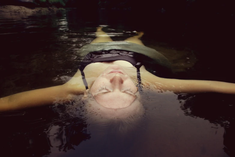a woman floating in the water with her head out