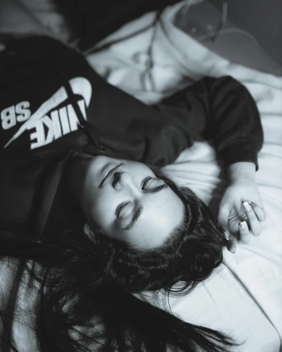 black and white pograph of young  laying on a bed