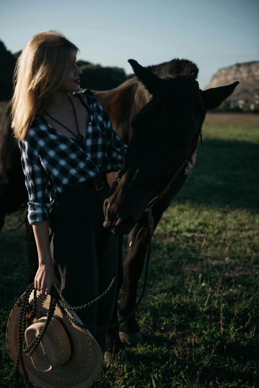 woman in a plaid shirt leaning on a brown horse