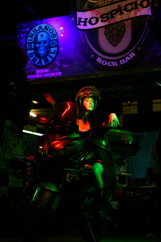 a woman is sitting on a motorcycle in the dark