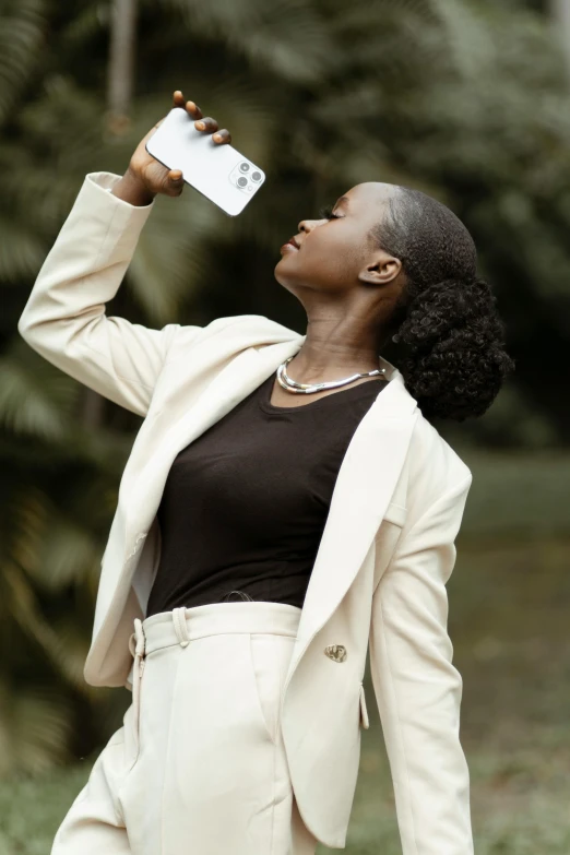 woman drinking water from a bottle in a grassy area