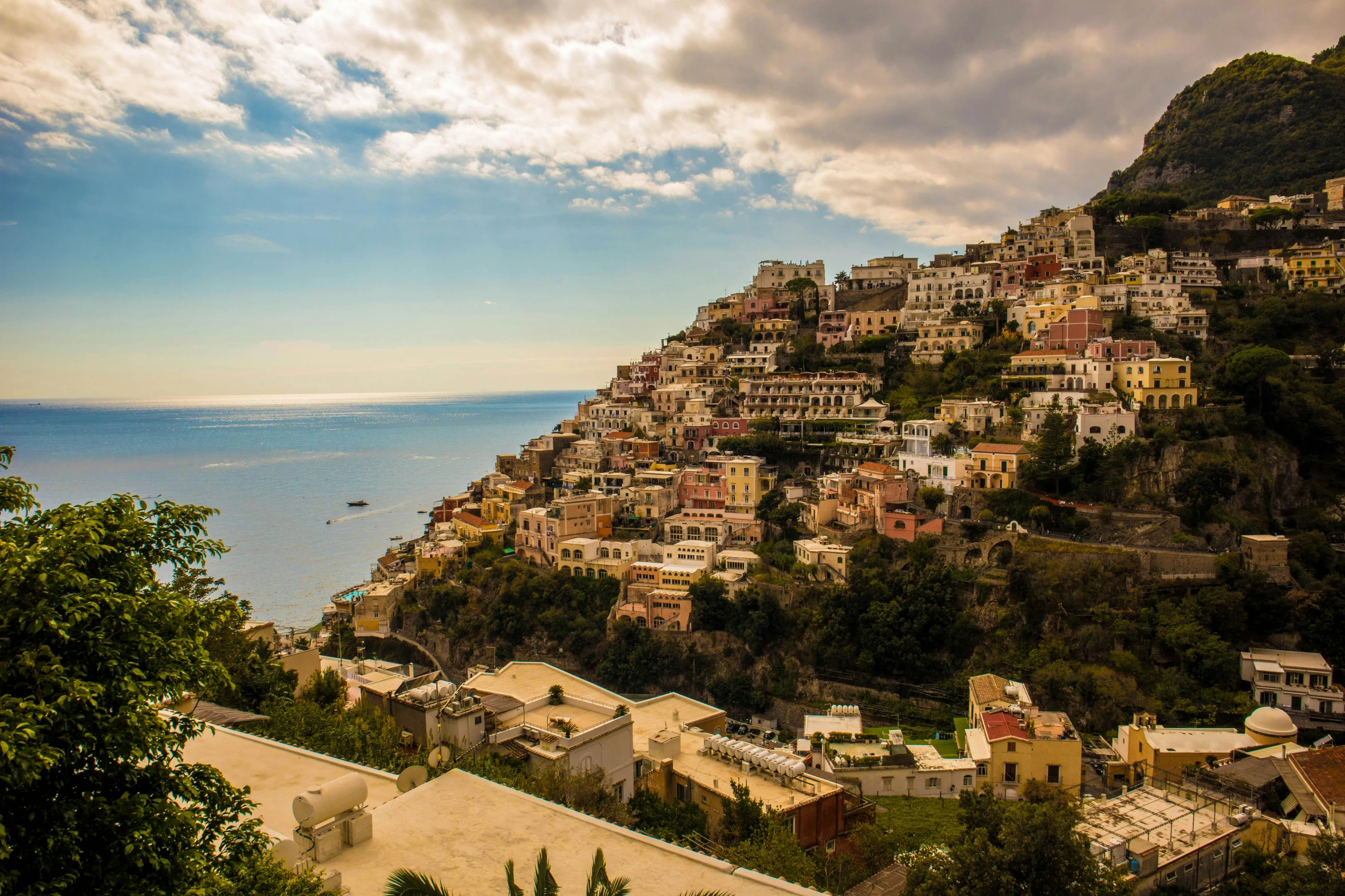 a mountain is overlooking a village by the sea