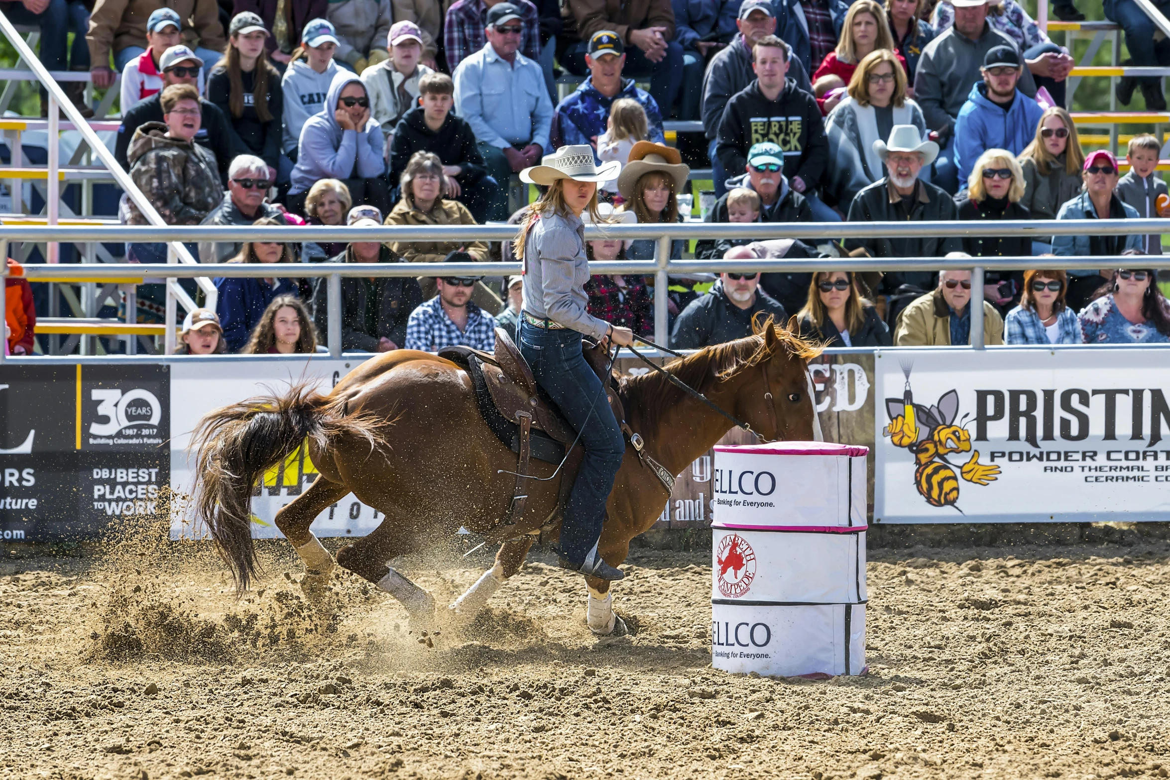 a woman is riding a brown horse in a rodeo