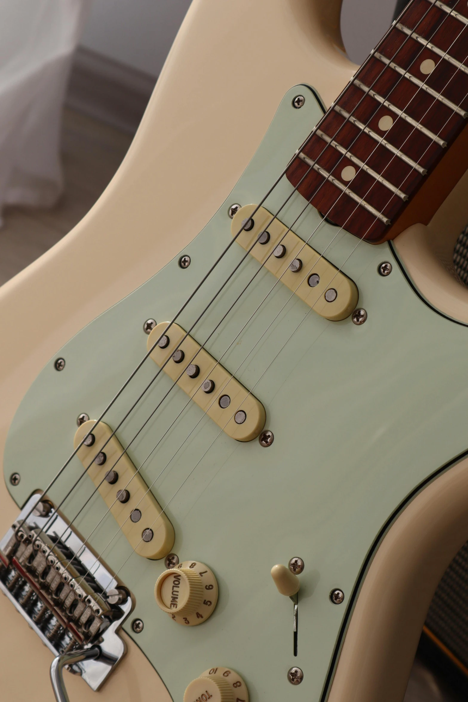 a green electric guitar on display in a room