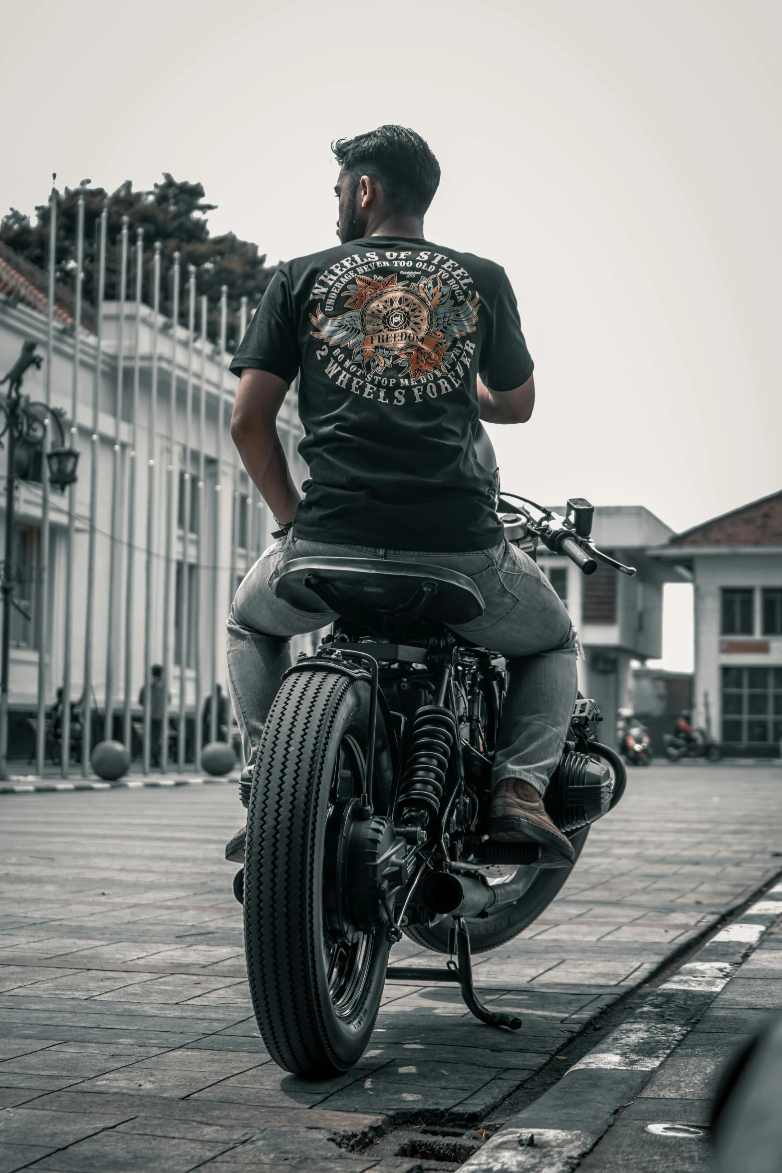 a black and white image of a man on a motorcycle