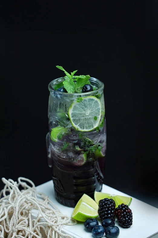 a glass with water and some fruit on a table