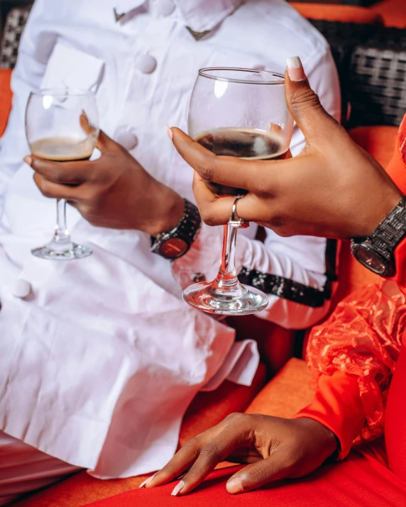 women hold their wine glasses while sitting down