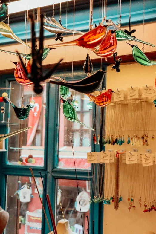 a wind indicator hanging in a window next to a small plant