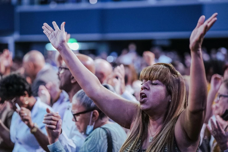 a group of people holding their arms in the air with their hands up