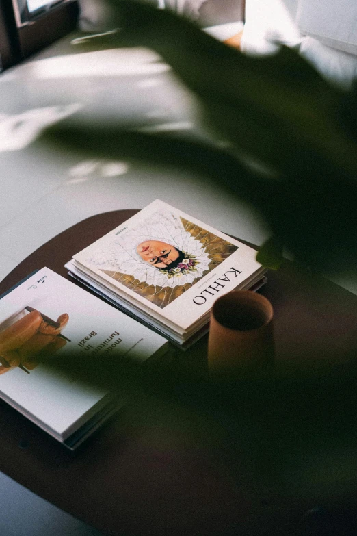 a table topped with an open book next to a cup