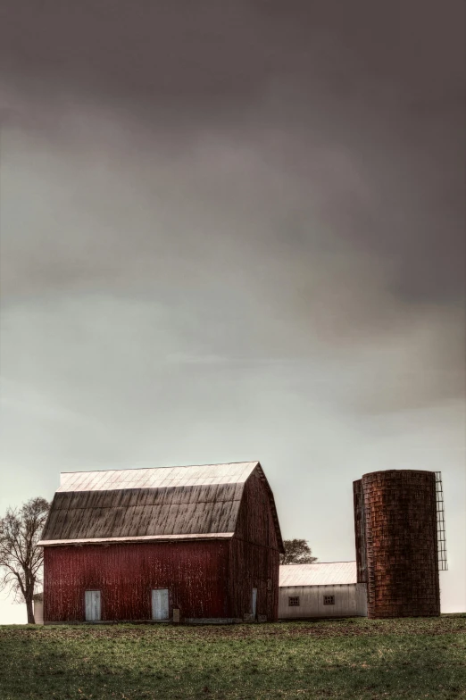 a red barn sits on the side of a hill