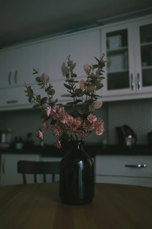 a vase of flowers sitting on a kitchen table