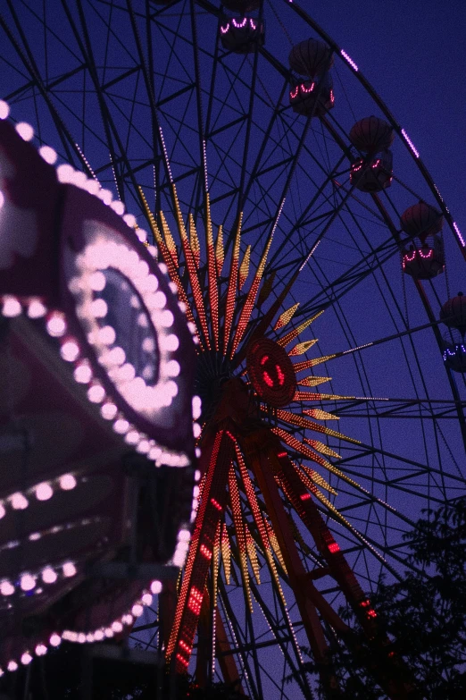 a ferris wheel with lights lit up against the night sky