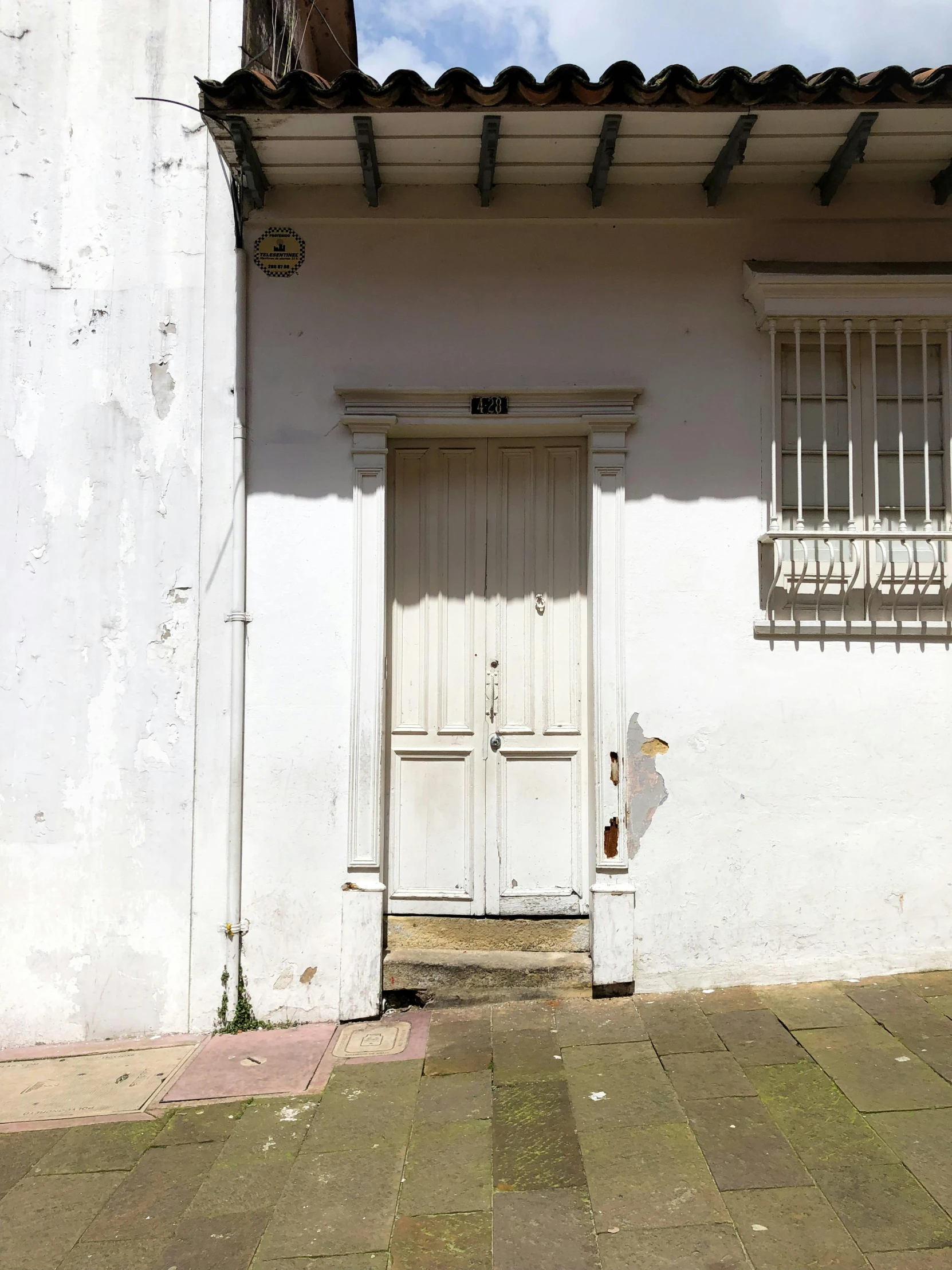 the front of a white building with a wooden door