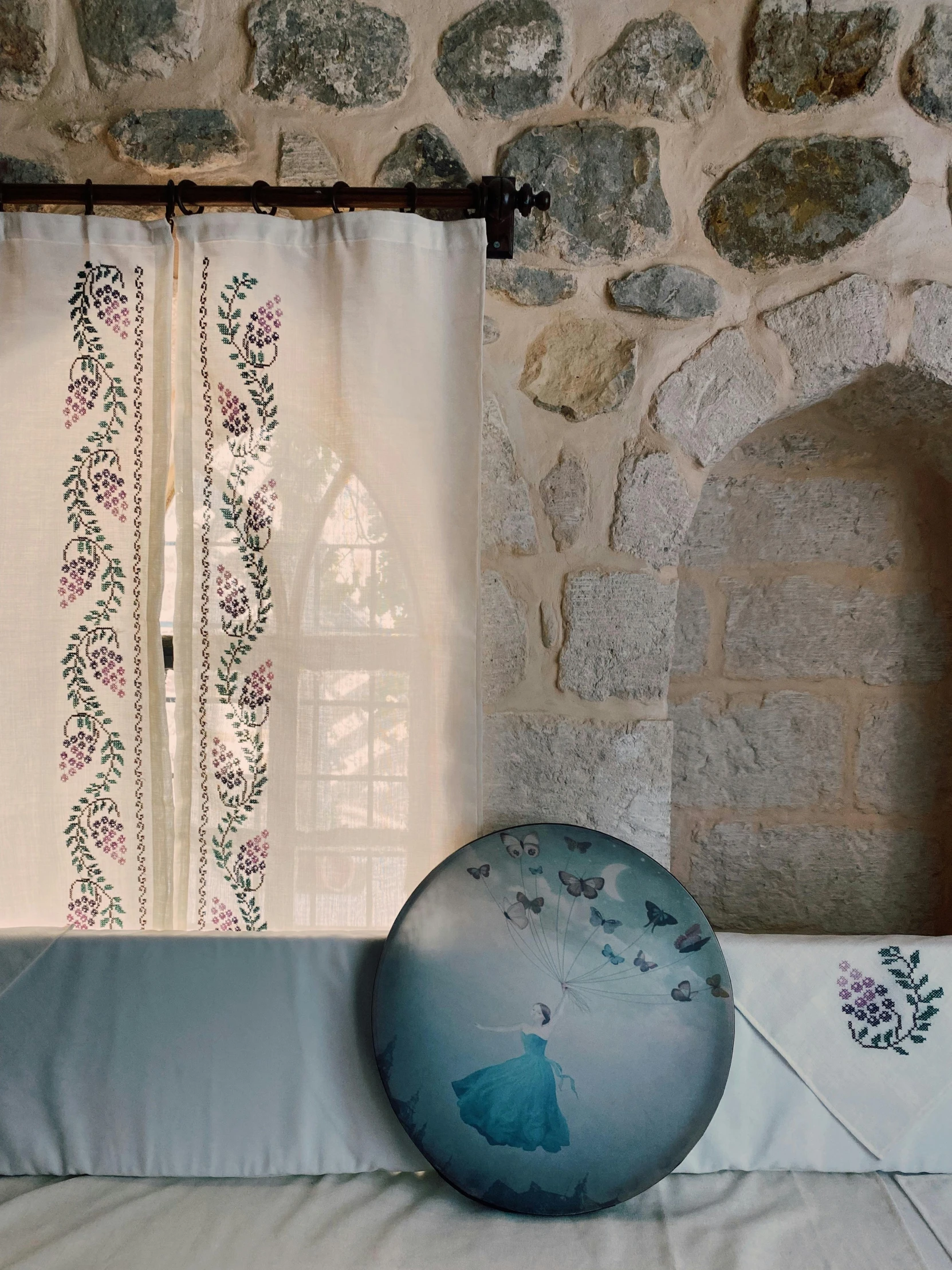 a stone wall and window behind the curtains