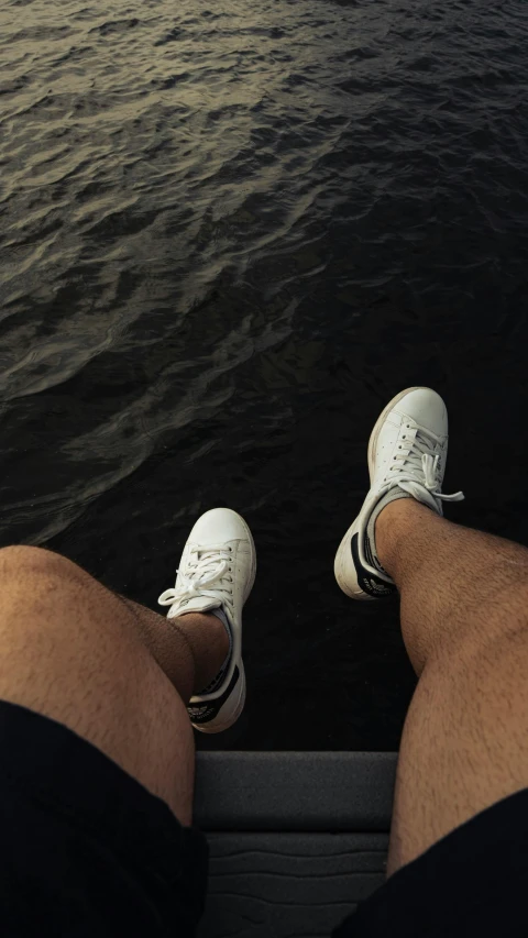 a pair of feet are seen out the window of a boat on the ocean